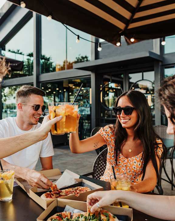 A group of people enjoying a meal together at an outdoor restaurant.