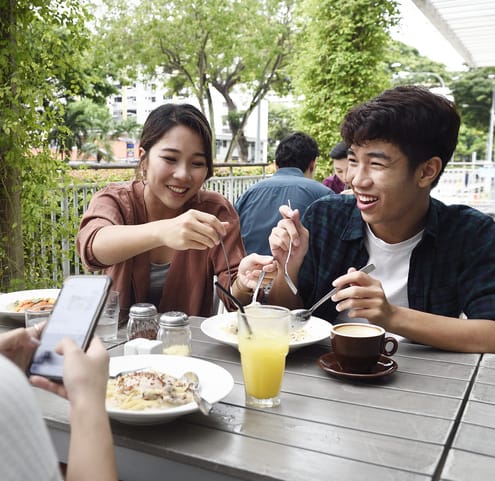 a group of people sitting at a table eating food