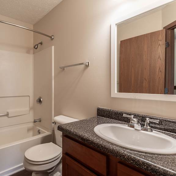 A bathroom with a toilet, sink, and bathtub.