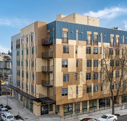 Exterior view of 6-story Bode 125 Apartment homes in Seattle, WA with blue and tan exterior colors