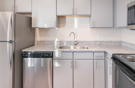 A kitchen with a stove, refrigerator, and microwave.
