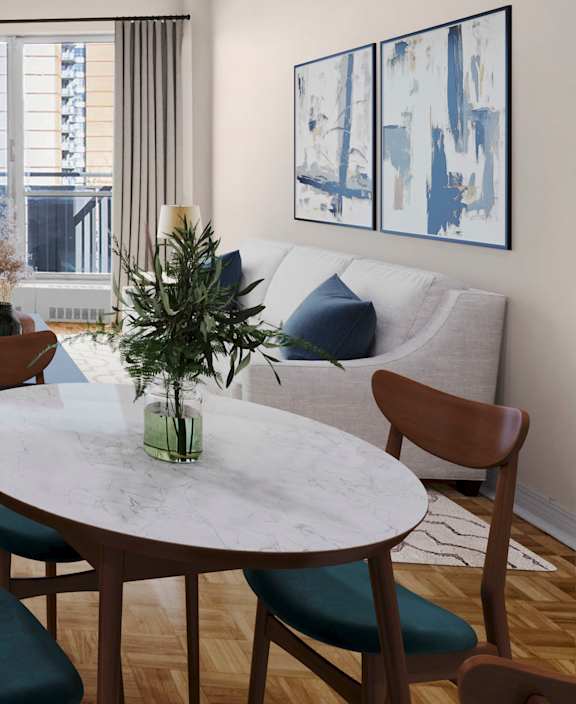 A living room with a white couch and a dining table.