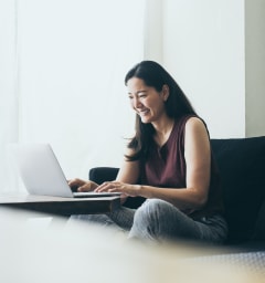 a woman sitting on a couch with a laptop