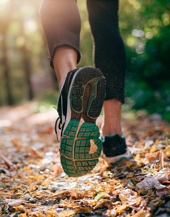 a woman walking on a trail in the woods