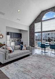 an open concept living room and dining room with a large window and a view of the pool
