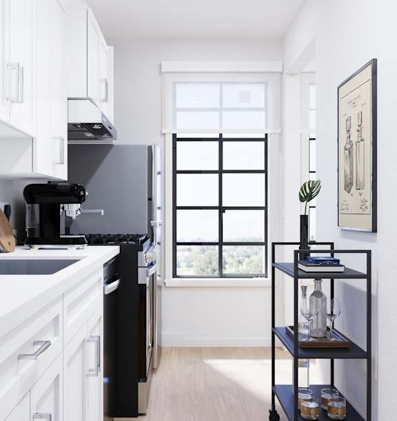 A black refrigerator in a kitchen with white cabinets.