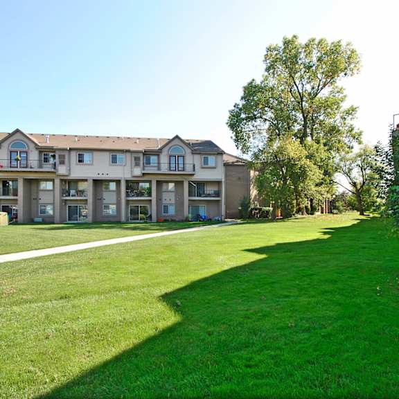 a green lawn in front of an apartment building