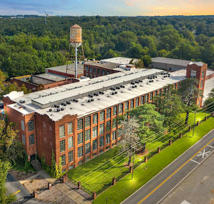 an aerial view of a brick building with a roofed facility