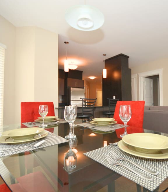 A modern kitchen with a stainless steel refrigerator and wooden flooring.