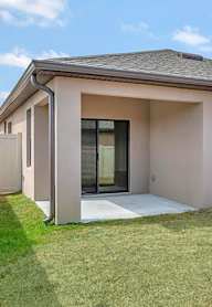 A house with a grey roof and a white fence.