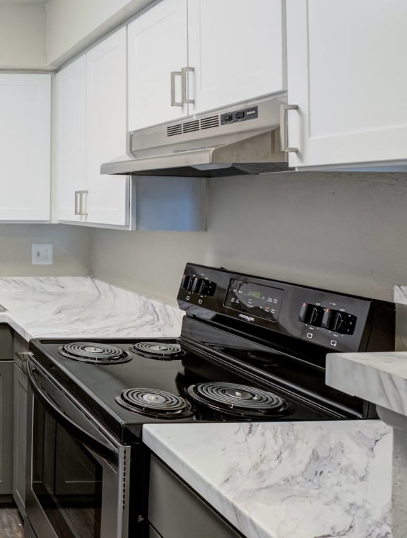 a kitchen with white cabinets and stainless steel appliances and a sink