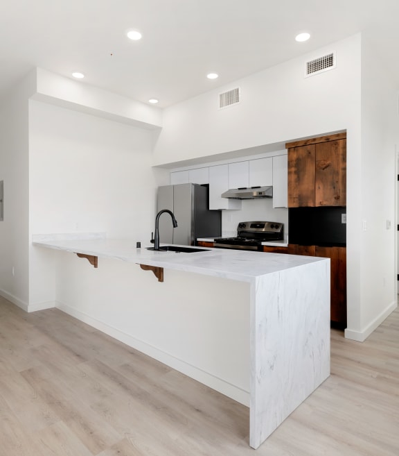 a living room with a gray couch and a wooden coffee table at Market Club at The Mill Apartments, Sacramento ,95818