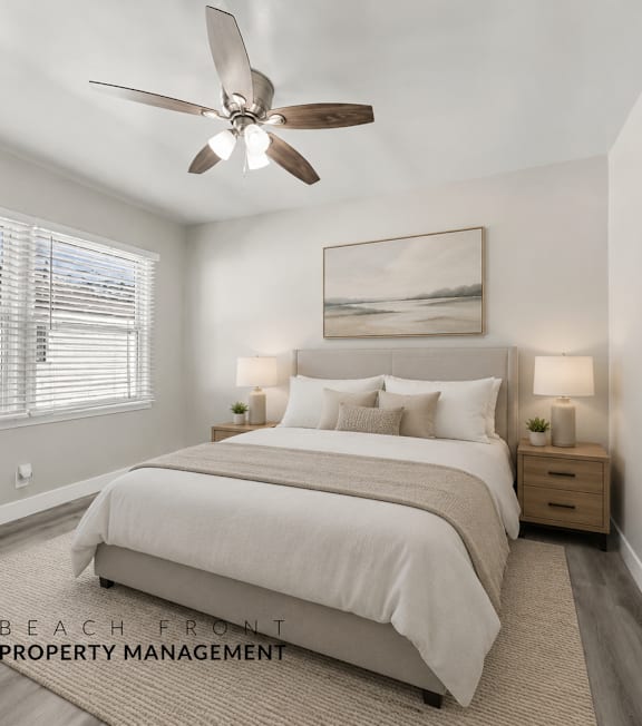 A well-lit bedroom with a large bed and a ceiling fan.