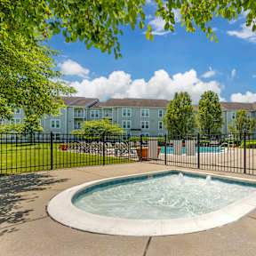 A hot tub sits in the middle of a concrete patio.