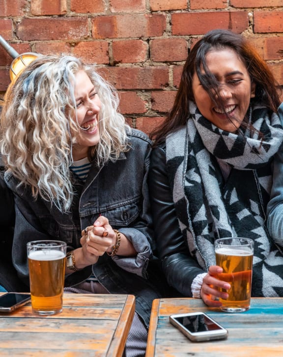 a group of people sitting at a table drinking beer