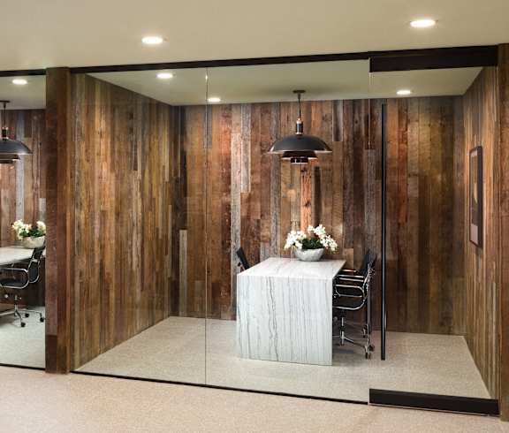 A room with wooden walls and a white table with chairs.