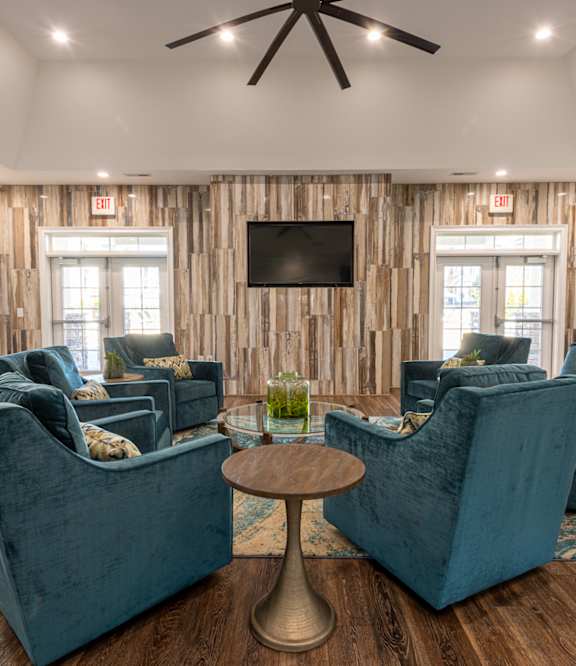 a living room with three mirrors and a wood floor