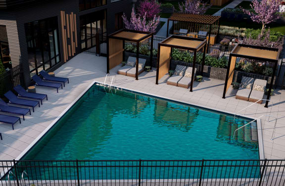 a swimming pool with blue lounge chairs and cabanas