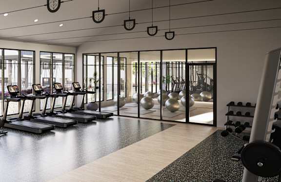 A gym with a variety of equipment including treadmills, weights, and exercise bikes.