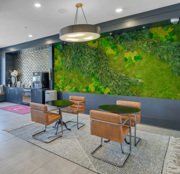 a living wall in the lobby of a hotel with tables and chairs