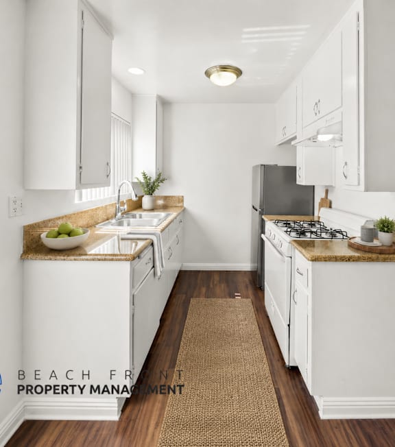 A kitchen with a fan and a mat on the floor.