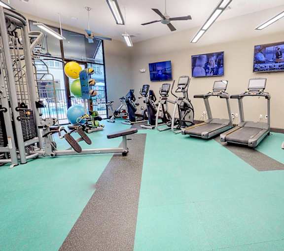 Gym with cardio machines and weights at Civic at Frisco Square Apartments, Frisco, TX, Texas
