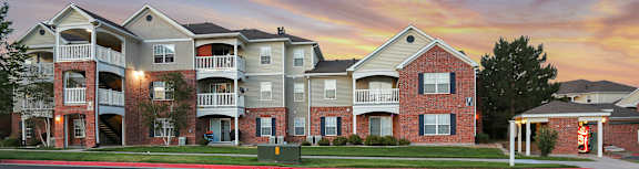 A row of apartment buildings with a car parked in front.