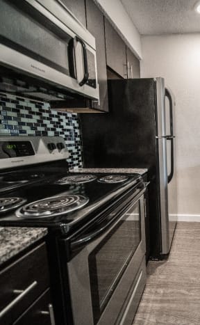 a kitchen with black and white appliances and granite counter tops