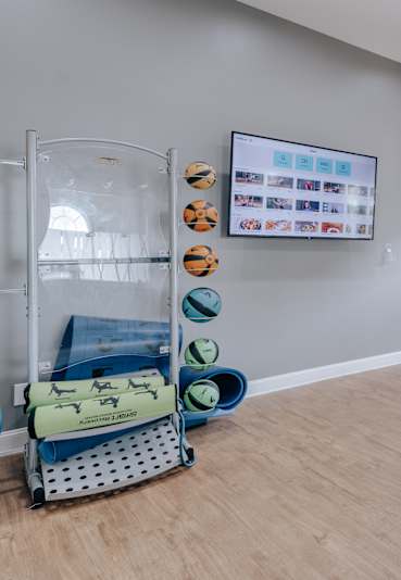 A room with a balloon on a cart and a wall with a screen and pictures.