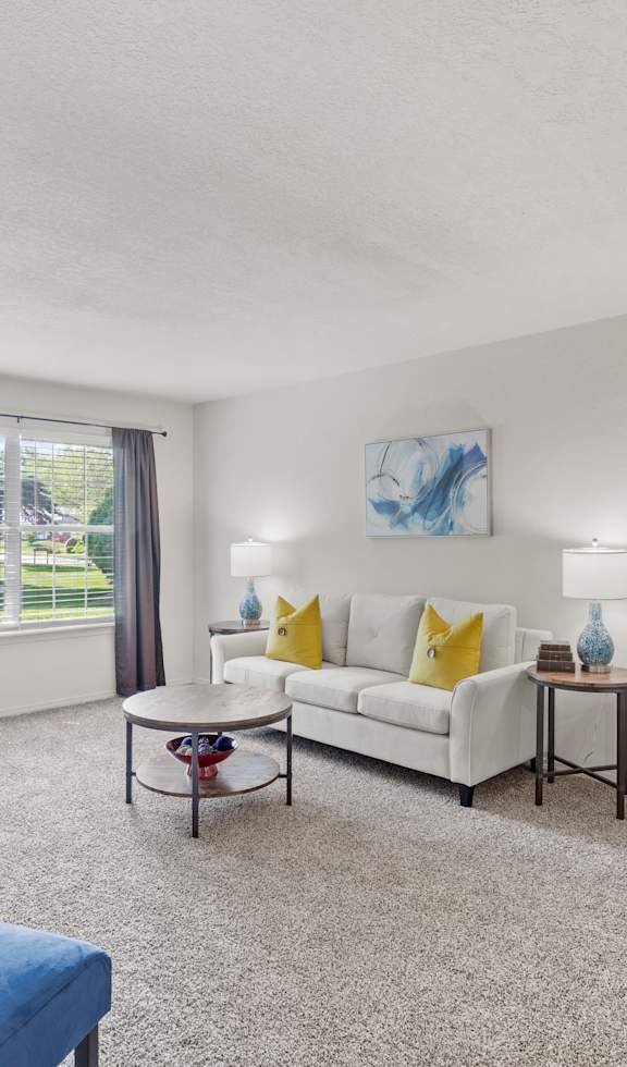 A bedroom with a bed, nightstand, and a painting on the wall.