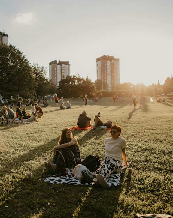 a woman and her dog sitting on the grass
