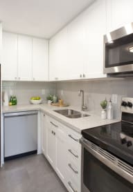 a kitchen with white cabinets and stainless steel appliances