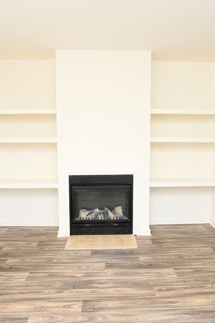 A living room with a fireplace and shelves. at The Regency, Manassas, VA, 20109