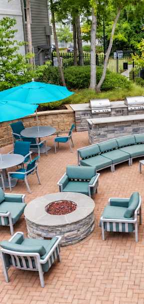 A patio with a table and chairs and a blue umbrella.
