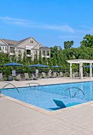 a swimming pool with umbrellas and chairs in front of a building