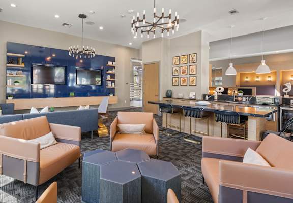 A modern living room with a bar area and a kitchen in the background.