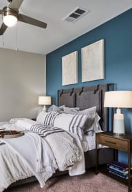 a bedroom with a large bed and a ceiling fan