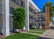 Thumbnail 20 of 22 - an exterior view of a building with green grass and a sidewalk