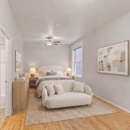 A bedroom with a bed, a couch, and a painting on the wall.