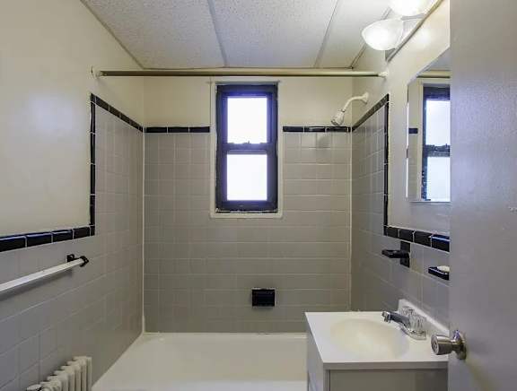 A white bathroom with a tub, toilet, and sink.