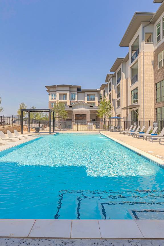 A swimming pool in front of apartment buildings.