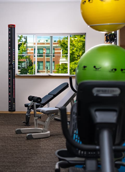 a gym with treadmills and exercise balls and a large mirror