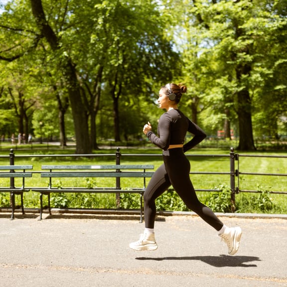a woman running in a park at Stone Creek at Old Farm Apartments, Houston, TX