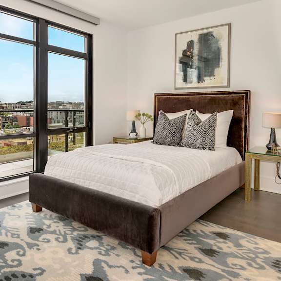 a bedroom with a bed and a large window