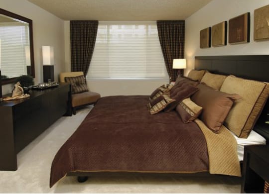 a bedroom with a bed and a dresser and a window