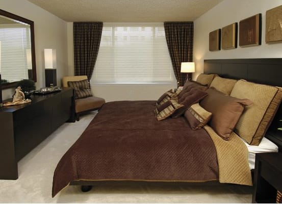 a bedroom with a bed and a dresser and a window
