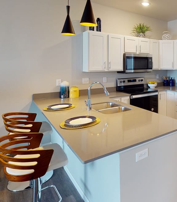 a kitchen with stainless steel appliances and a counter topat First Street Lofts in Downtown Bismarck, Bismarck, ND, 58506