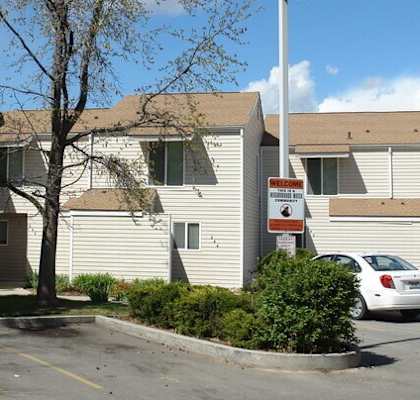 A white building with a parking lot in front of it.