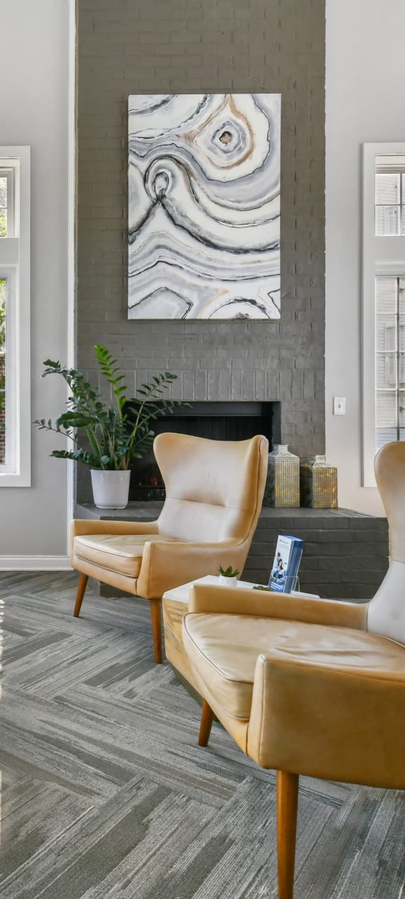 a living room with leather chairs and a fireplace