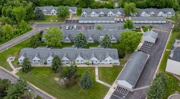 A bird's eye view of a residential area with houses and a parking lot.